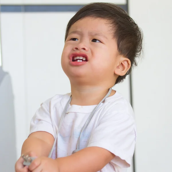 Pictures of cute Asian boy pulling electrical wire from the neck — Stock Photo, Image