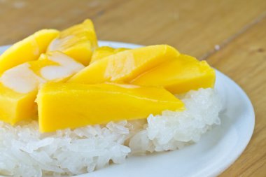 Yapışkan pirinç çanağı ve ahşap masa Mango ile