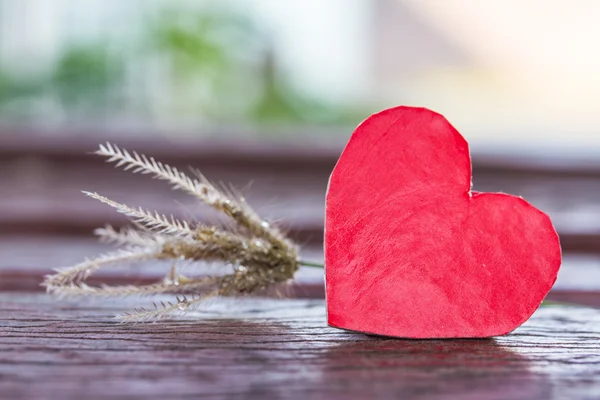 Red heart and blur flower grass on wood — Stock Photo, Image