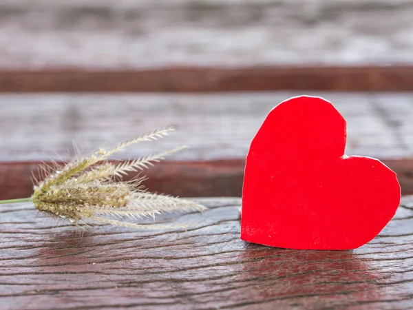 Red heart and grass flower on wood — Stock Photo, Image