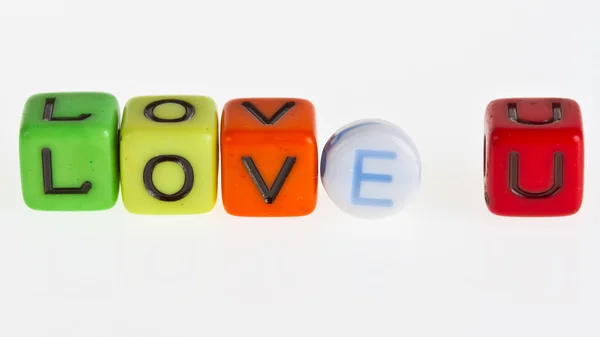 Plastic blocks spelling out the word LOVE U on white background — Stock Photo, Image