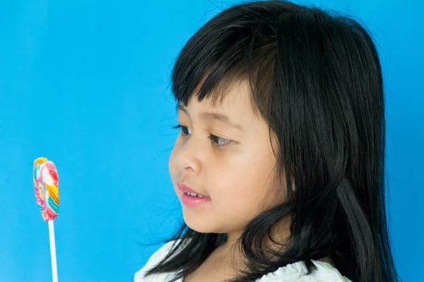 Portrait of little girl looking at her sweet candy. Isolated on — Stock Photo, Image