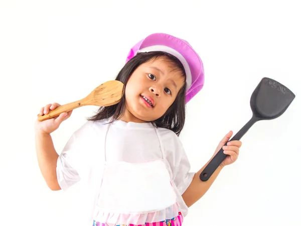 Liten flicka cook håller en slev på vit bakgrund. — Stockfoto