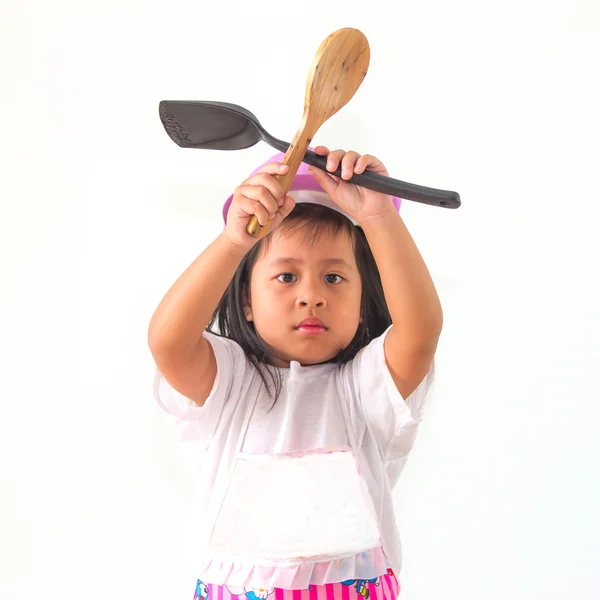 Liten flicka cook håller en slev på vit bakgrund. — Stockfoto