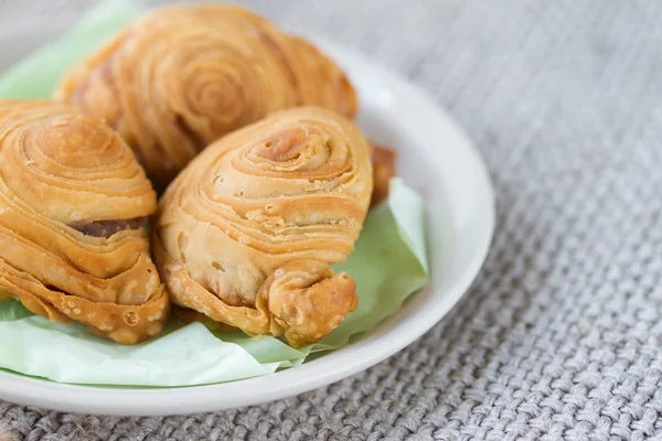 Bilden av curry puff i vitt keramikfat på säck bakgrund — Stockfoto