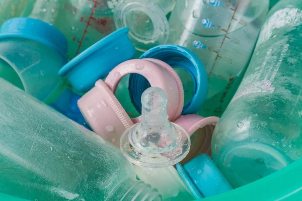 Kirli emzikler ve bir kova şişe mavi plastik.