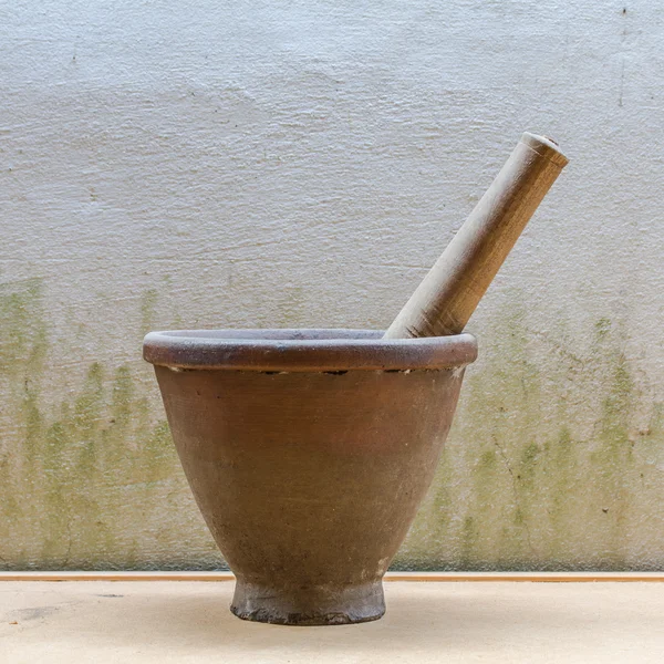 Mortar with wooden pestle on wall background — Stock Photo, Image