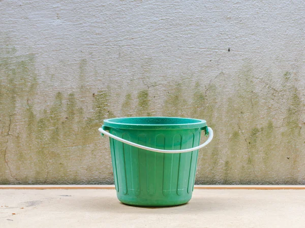 Water bucket on wall background and wooden — Stock Photo, Image