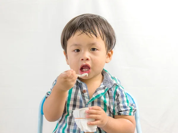 Happy healthy boy eating yogurt on white — Stock Photo, Image