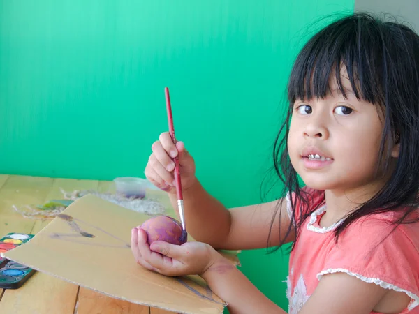 Niña está pintando huevos preparándose para Pascua — Foto de Stock