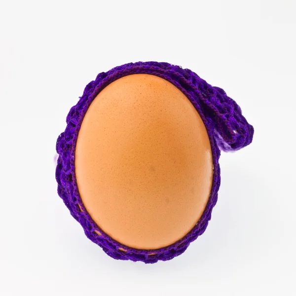 Яйца завернуты в фиолетовую ткань на белом фоне — стоковое фото