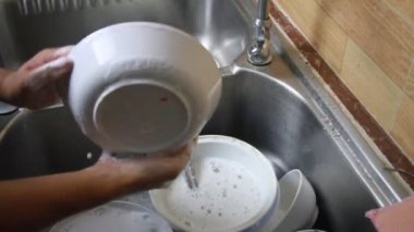 bir adam bulaşık yıkar
