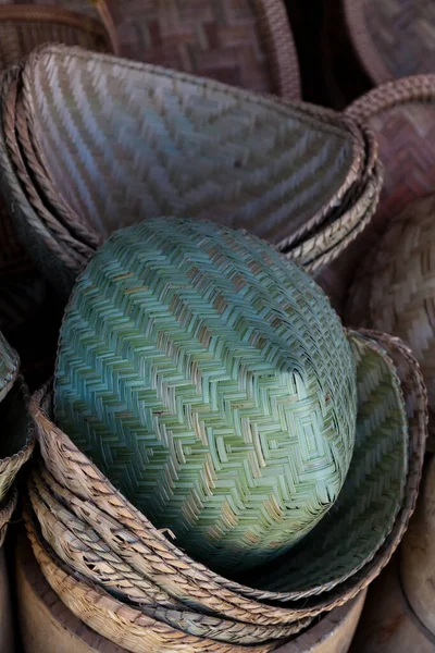 Laos, wicker woven reed baskets and containers in market, patterned weaving