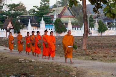 Muong Khong Laos 1.12.2012 Şafak sökerken köyde pirinç toplamak için keşişler