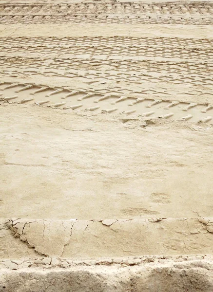 Sand construction site with traces of construction equipment and tractor