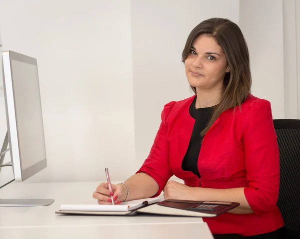 Mujer de negocios en rojo cintura abrigo escritura notas Imagen de stock