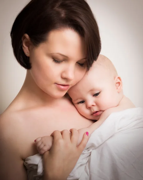 Jovem mãe em íntimo abraço com seu bebê — Fotografia de Stock