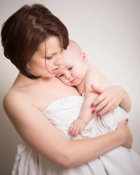Jovem mãe em íntimo abraço com seu bebê — Fotografia de Stock