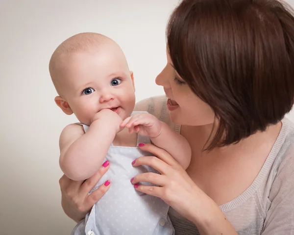 Giovane madre holding sorridente bambino in armi Foto Stock