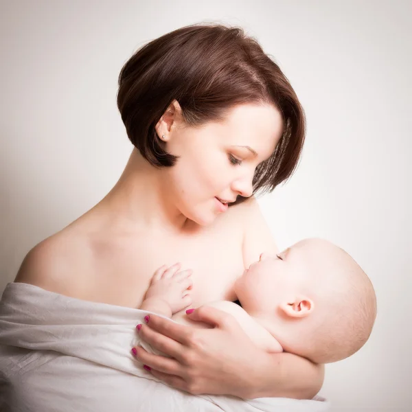 Ung mamma i intima gosa med sin Baby Stockfoto