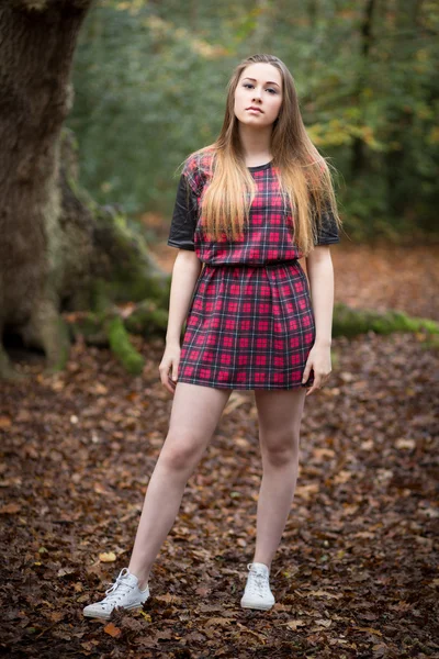 Retrato de una hermosa adolescente de pie en un bosque — Foto de Stock