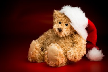 A Brown Teddy Bear Wearing a Christmas Hat clipart