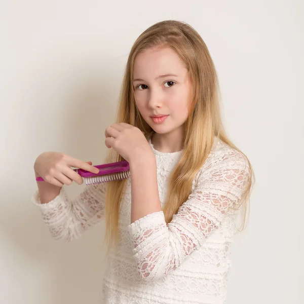 Genç ve güzel sarışın kız saçları fırçalama — Stok fotoğraf