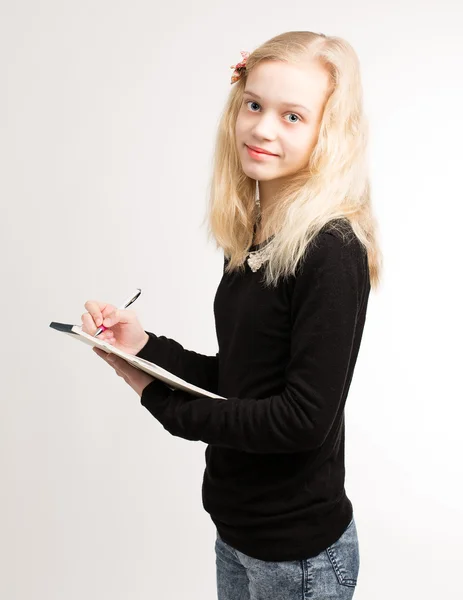 Blond tonåring tjej skriva anteckningar om anteckningar — Stockfoto