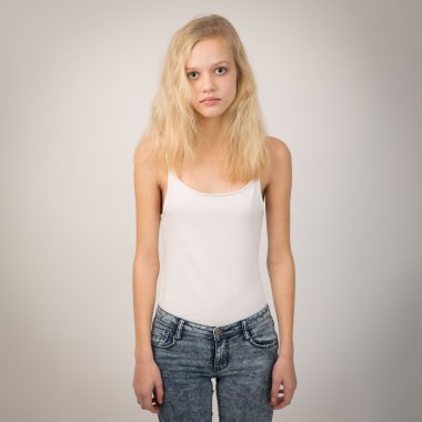 Blond Serious Girl Standing Straight Wearing A White Top