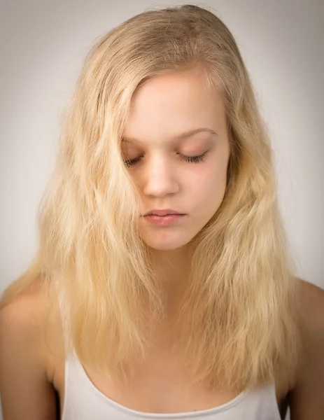 Schöne ernsthafte blonde Mädchen mit geschlossenen Augen — Stockfoto