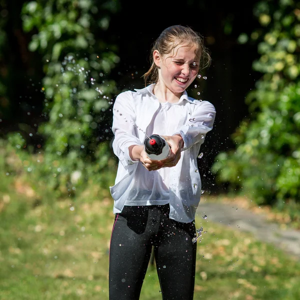 Mojado adolescente chica chorros agua de botella Imagen de stock