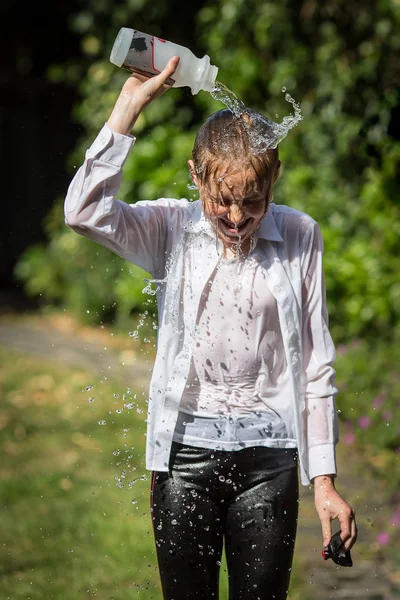 Adolescente chica se enfría por tirar agua sobre su cabeza Imagen de stock