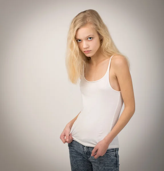 Beautiful Blond Teenage Girl In White Top And Jeans Royaltyfria Stockfoton