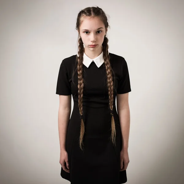 Vacker tonårig flicka med flätor klädd i svart Stockbild