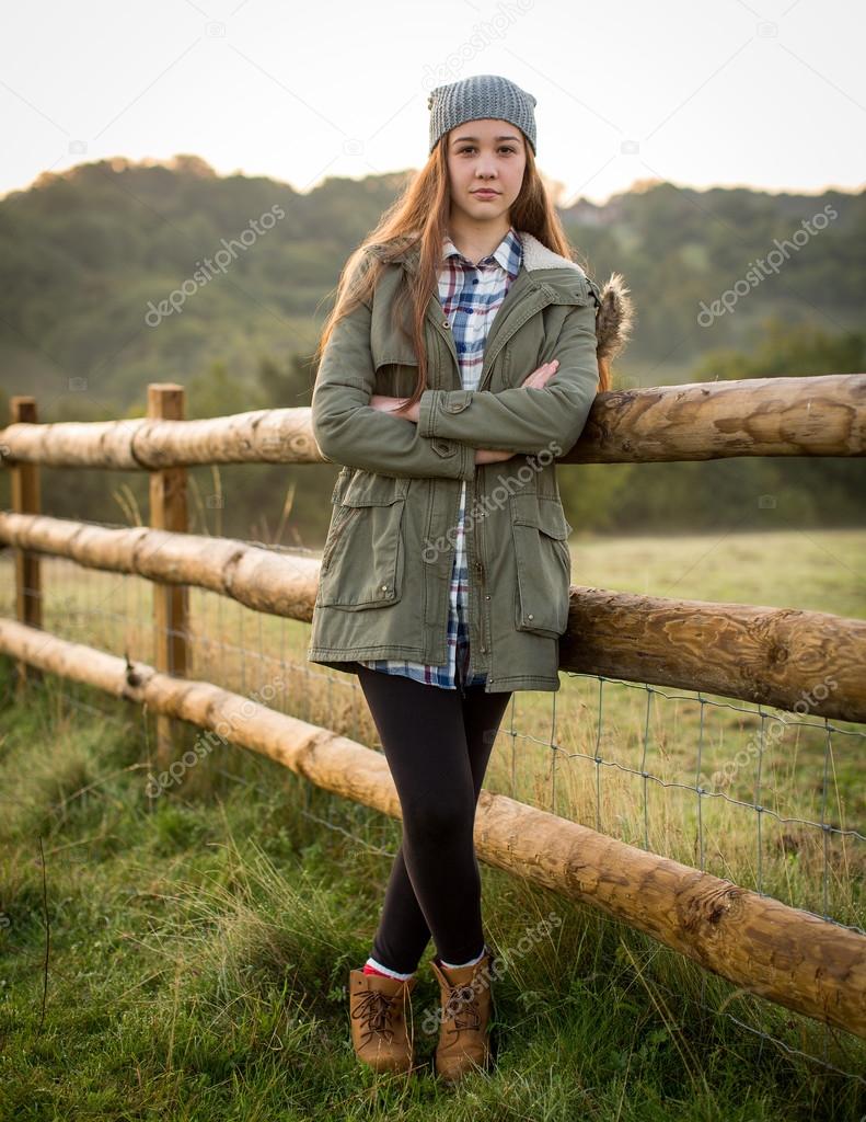 Beautiful Teen Girl Leaning Against A Farm Fence