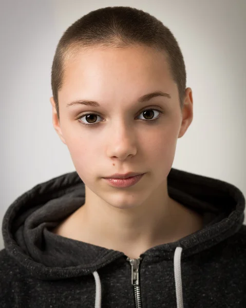 Hermosa joven adolescente con la cabeza afeitada y con una sudadera con capucha — Foto de Stock