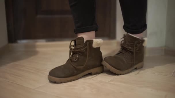 一个女人在她的公寓里脱下了她的冬靴 — 图库视频影像