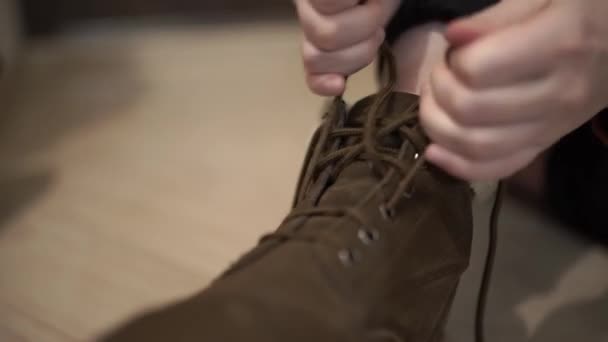 这个女孩正在把鞋带绑在她的靴子上 她在屋里穿上靴子 — 图库视频影像
