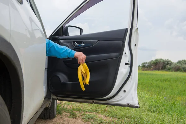 Mão Uma Mulher Através Porta Carro Aberto Joga Cascas Banana — Fotografia de Stock