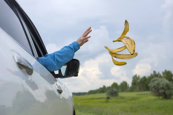 Mano Una Mujer Arroja Cáscaras Plátano Por Ventana Del Coche — Foto de Stock