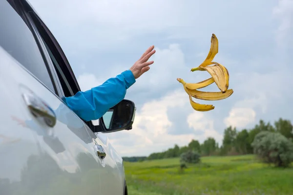 Mano Una Mujer Arroja Cáscaras Plátano Por Ventana Del Coche — Foto de Stock