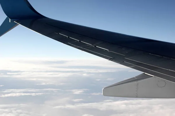 view of the plane wing and clouds from the plane window