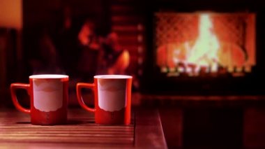 Şöminenin önünde Noel Baba resmi olan kupalar. Neşeli, rahat bir Noel ya da yeni yıl havası.