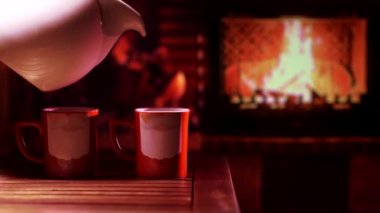 Şöminenin önünde Noel Baba resmi olan kupalar. Neşeli, rahat bir Noel ya da yeni yıl havası.