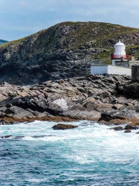 Okyanustaki kayalıklarda deniz feneri İnanılmaz İrlanda manzarasında