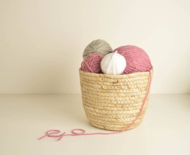 Pastel renkli yün toplar sepetin içinde, el işi için kancalarla.