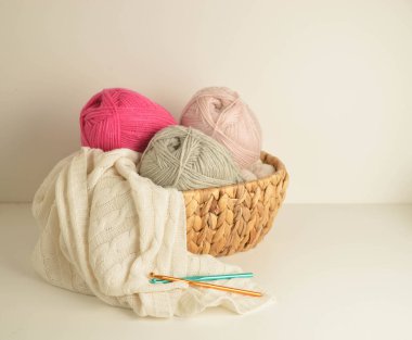 yumuşak renkli yün toplar sepetin içinde örgü kancası ve beyaz yün bir battaniye