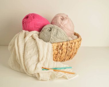 yumuşak renkli yün toplar sepetin içinde örgü kancası ve beyaz yün bir battaniye