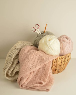 yumuşak renkli yün toplar kahverengi sepetin içinde makas ile