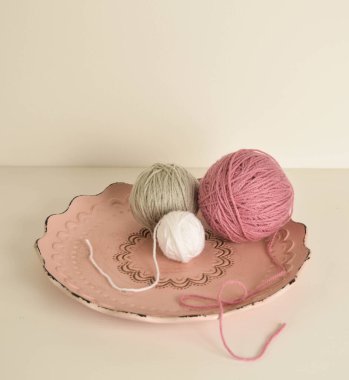 Yün atkılı pembe ve beyaz yün toplar.